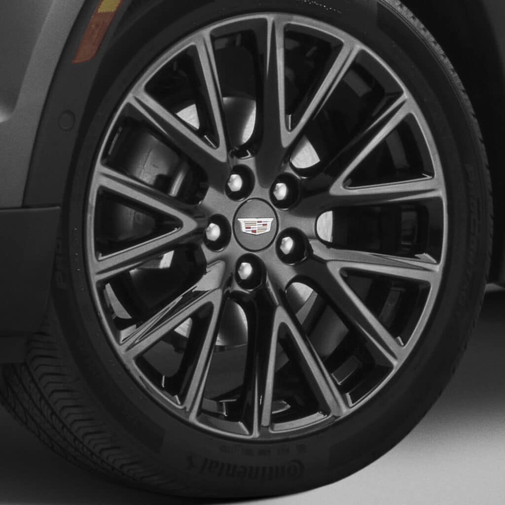 Cadillac wheel with sleek black alloy rims and a visible tire tread pattern.