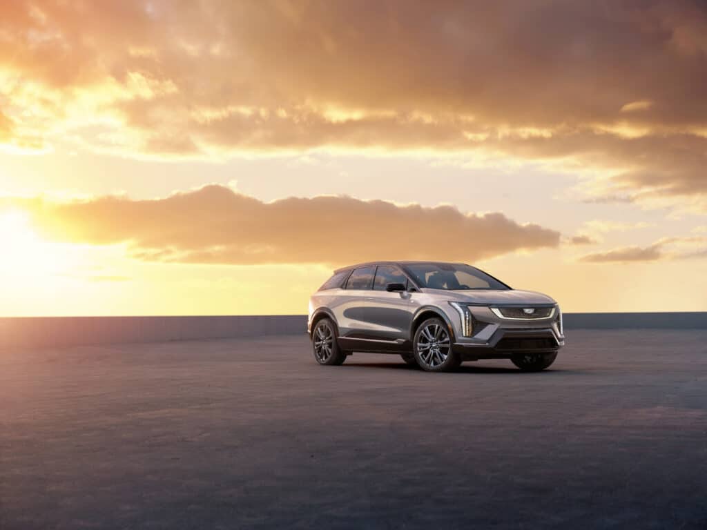 Silver SUV parked under a vibrant sunset, emphasizing modern design and elegance.